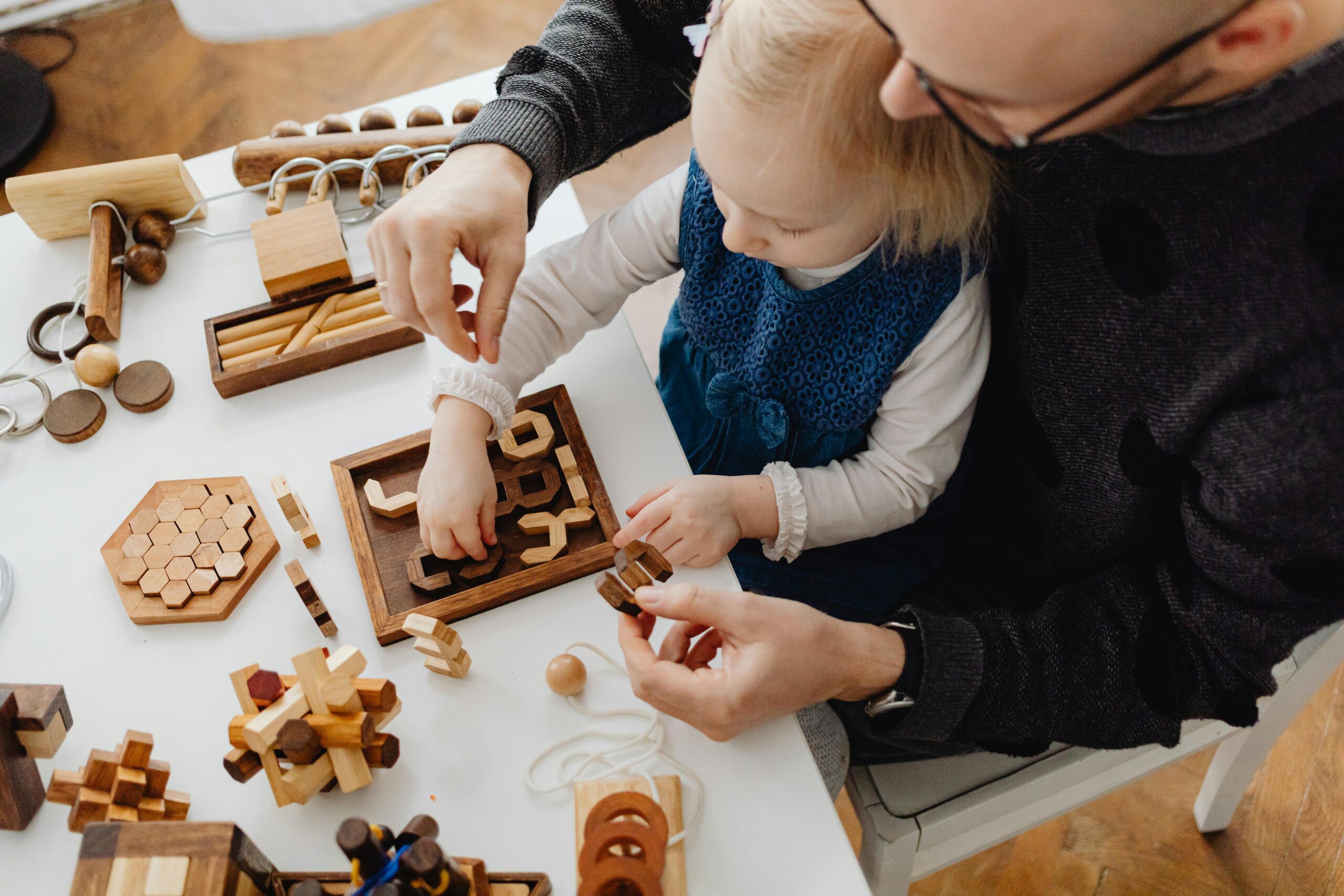 Father and daughter playing with wooden educational toys, fostering bonding and development.